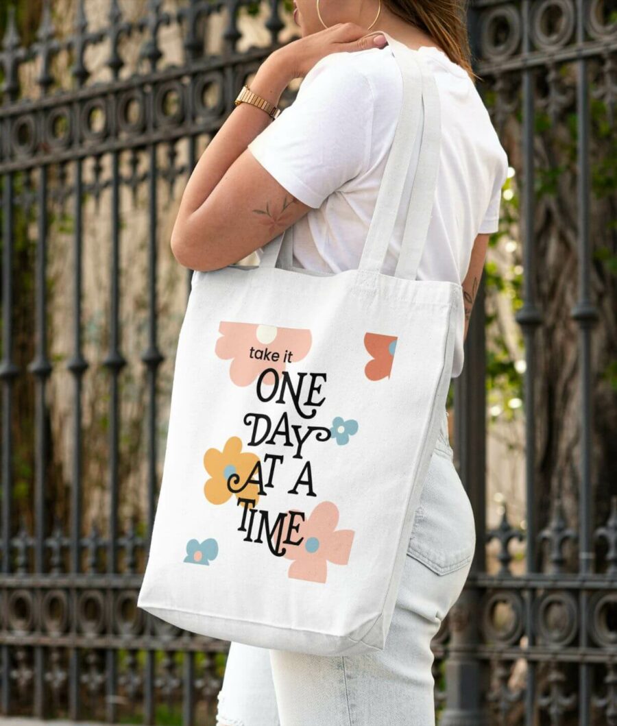 Girl wearing the "One day at a time" tote bag